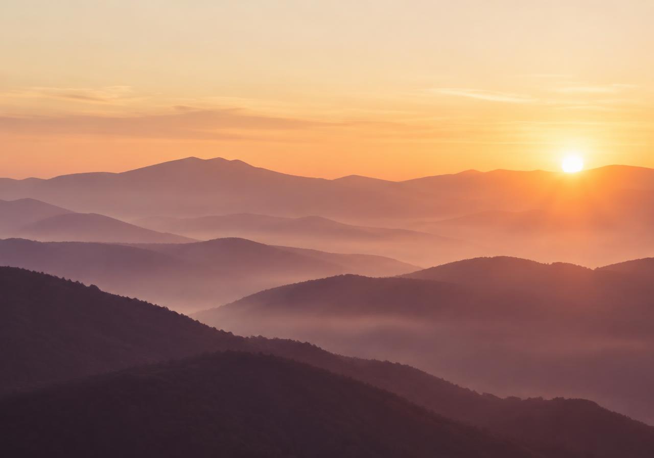 Soft sunrise over misty mountain ridges in warm apricot and plum light